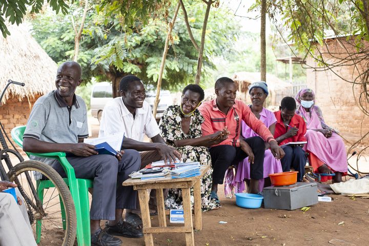 Syv medlemmer til en spare- og lånegruppe i Uganda under et møte.