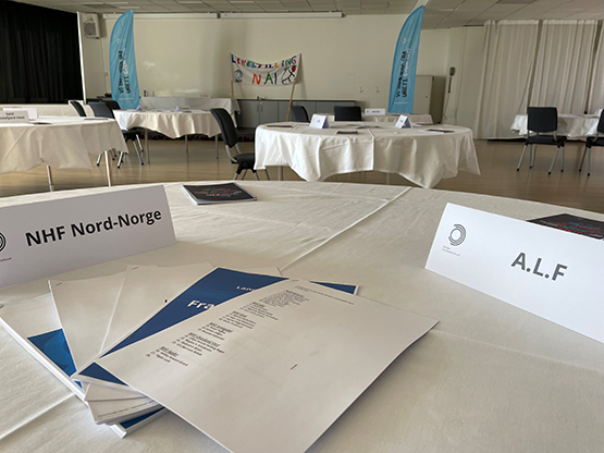 Rundt bord med møtepapirer og papirskilt for NHF Nord-Norge og ALF